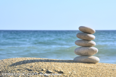Stones balances on the beach of blue sea 